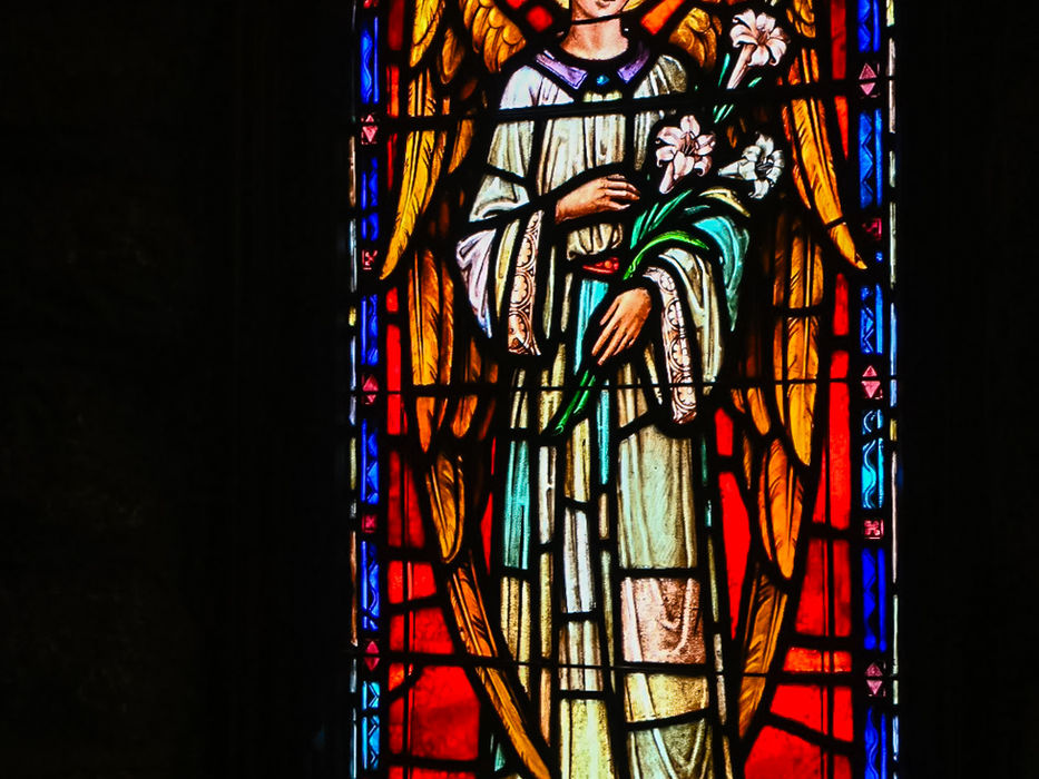 Stained glass angel holding lilies