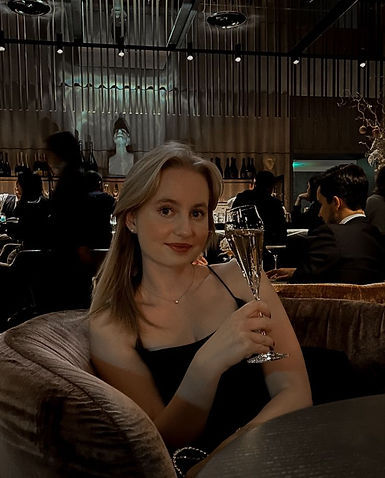 Blonde girl, laughing, drinking champagne at exclusive, high end, luxury hotel bar.