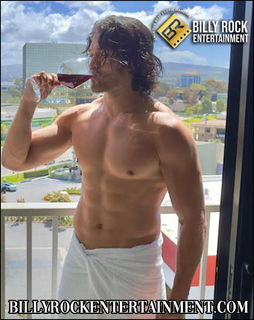 Chino: Male dancer Chino on a balcony, sipping red wine against a cityscape backdrop.