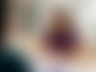 Mulher de blusa roxa sorri em consultório de neuropsicóloga em Brasília, com formulário sobre a mesa fazendo uma avaliação neuropsicológica.