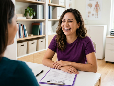 Mulher de blusa roxa sorri em consultório de neuropsicóloga em Brasília, com formulário sobre a mesa fazendo uma avaliação neuropsicológica.