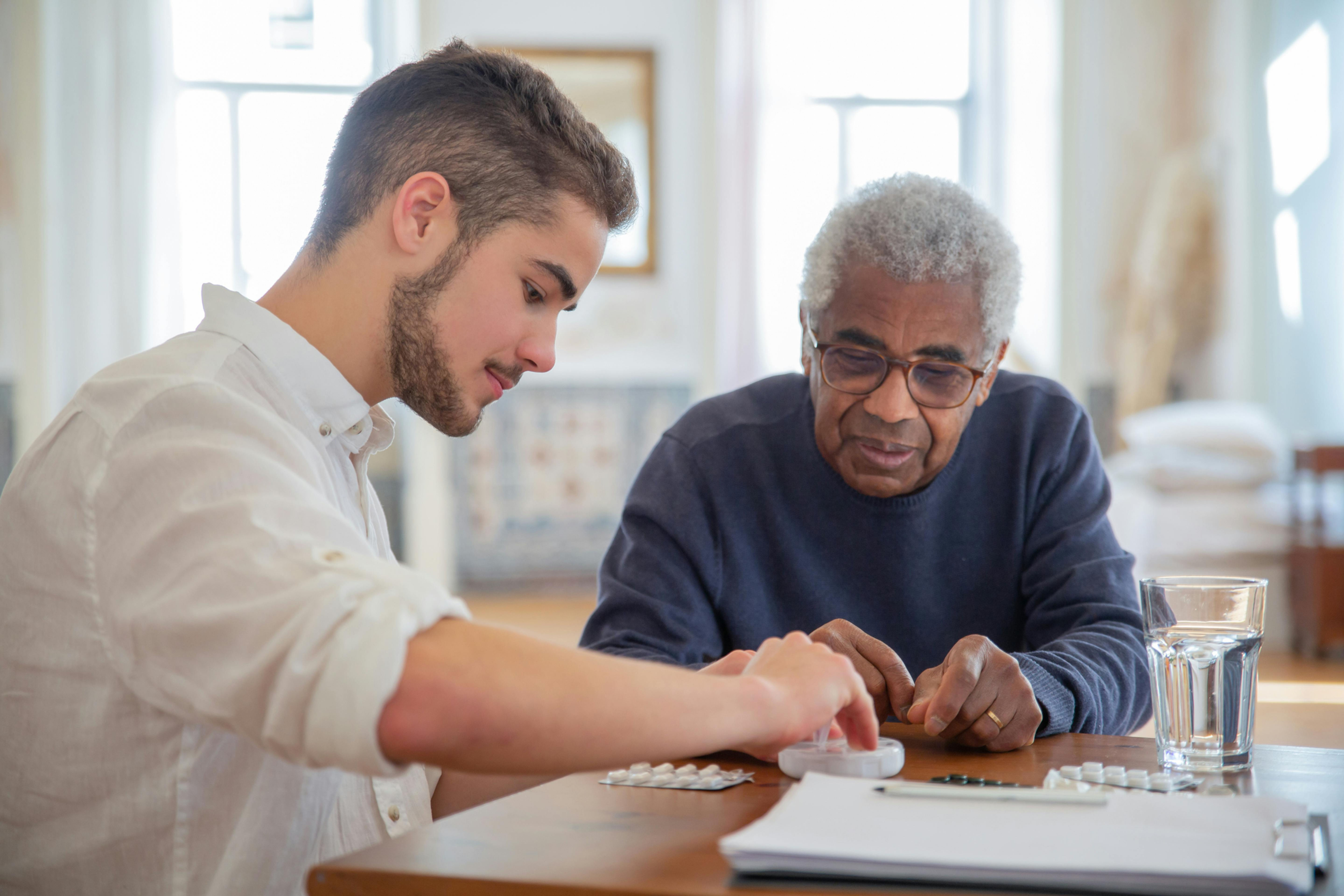 caregiver helping elderly man