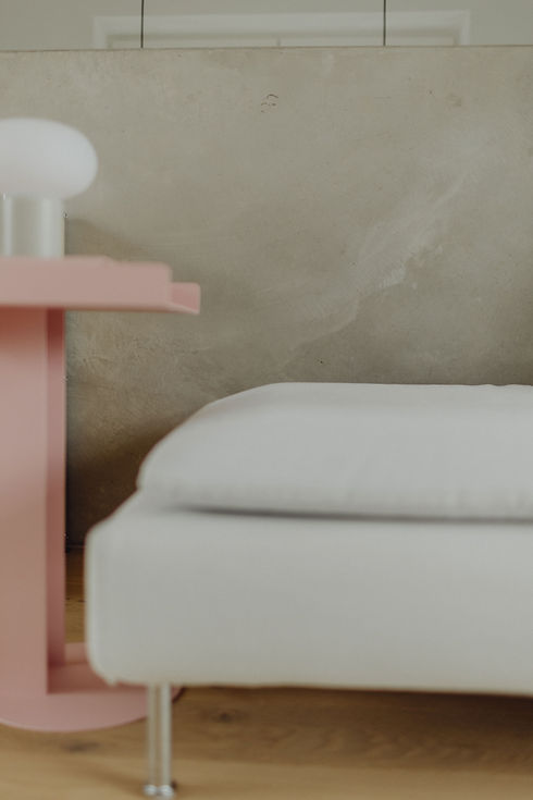 Materialehrliche Innenarchitektur: Kombination aus weichem Sofa, USM-Sideboard und warmem Tageslicht