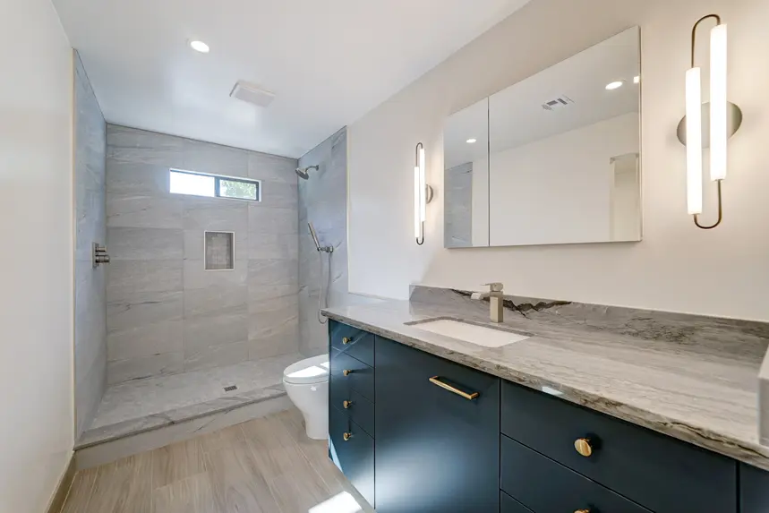 Interior guest house bathroom with vanity, mirror, and walk-in shower