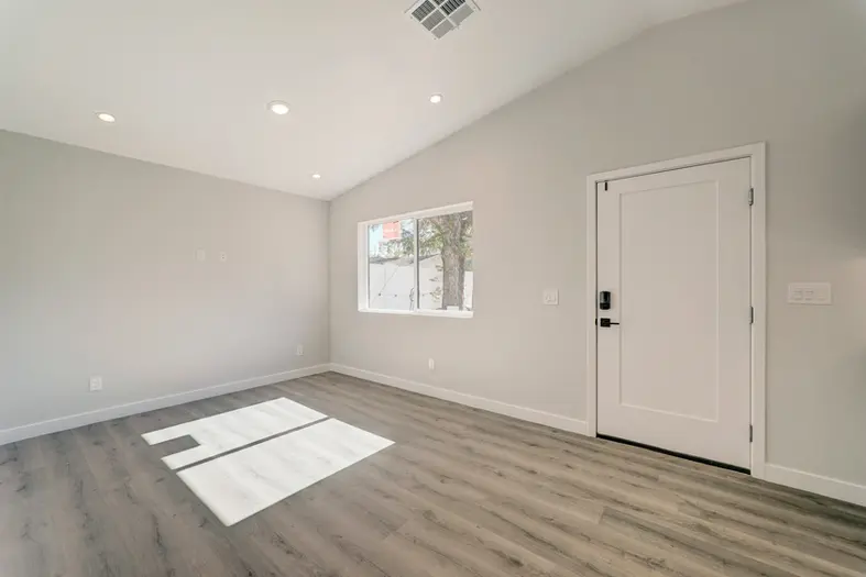 Interior view of a modern ADU front door and living area with clean lines and minimalist hardware.