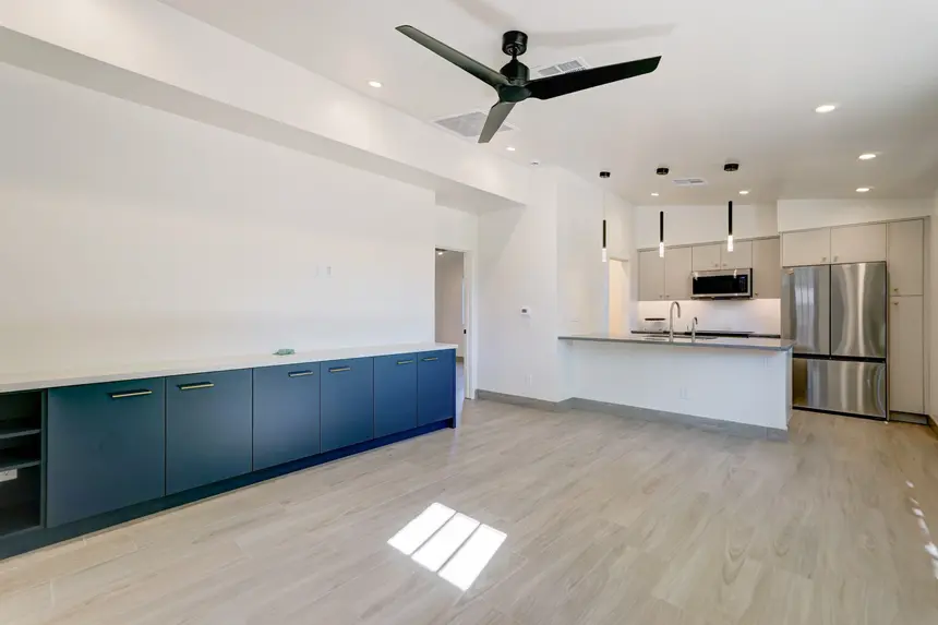 Interior guest house front entry living room with view of built-in media console and kitchen