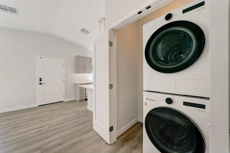 Stacked LG washer and dryer unit installed in a dedicated utility closet within a Phoenix ADU.