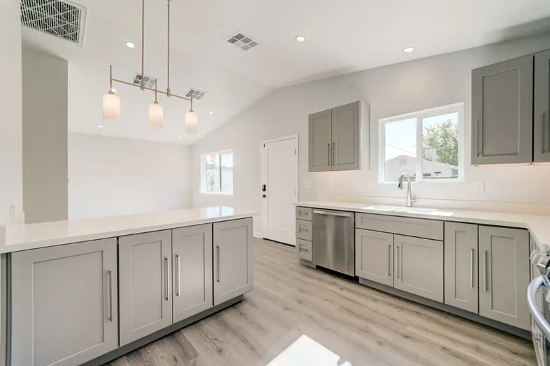 Bright open-concept ADU kitchen and dining area featuring vaulted ceilings and modern lighting.