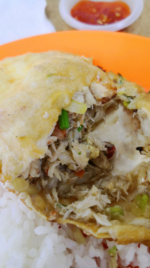 A close-up of the famous Kemaman stuffed crab from Restoran Tong Juan, revealing a dense and flavorful filling of crab meat served over white rice.