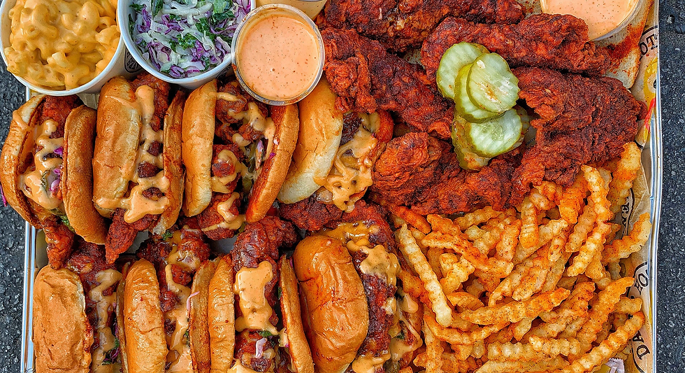 Tray of fried chicken sandwiches with pickles, crinkle fries, mac and cheese, slaw, and dipping sauce on a counter - TGI F from resorts world birmingham