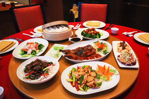 A luxurious full-table spread at Lotus featuring dim sum, roasted duck, and various Cantonese specialties for group dining.