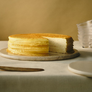 The iconic Lady M Signature Mille Crêpes cake with its characteristic golden caramelized top and numerous delicate layers.