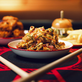 A gourmet Asian-inspired salad bowl at RedTail, served with chopsticks in a vibrant social setting.