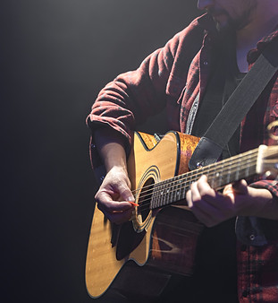 male-musician-playing-acoustic-guitar-dark-room-copy-space.jpg