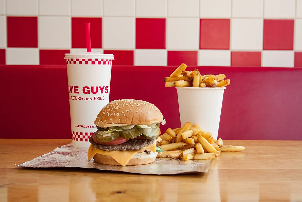 Five Guys burger, fries, and drink on a tray against a red-and-white tiled wall - five guys from resorts world birmingham