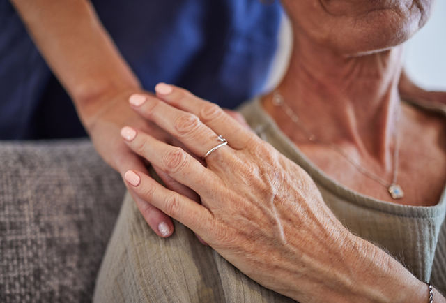 Older couple holding hands with wedding rings, representing family protection and estate planning services
