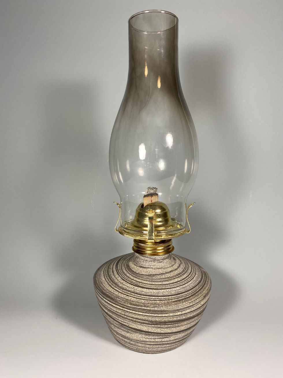 a ceramic oil lamp with a clear glass shade