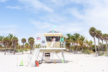 Photo d'un couple marié dans une tour de sauveteur sur la plage à Miami, Crandon park