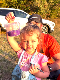 Happy child holding a just made bucket of SLIME at mobile event
