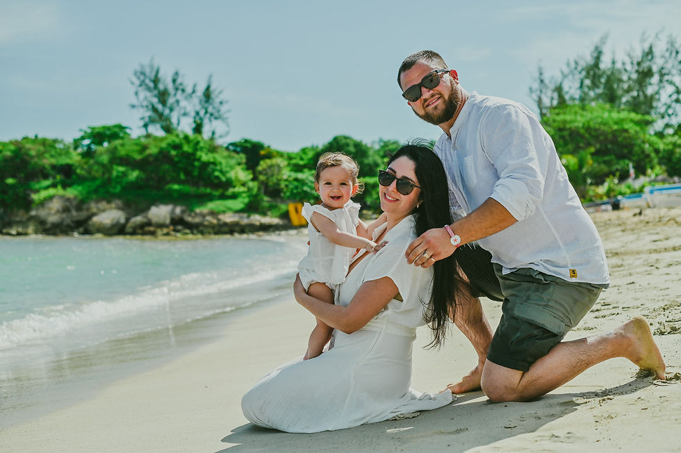 Familia uruguaya con su bebé de un año sonriendo en la arena de Playa Macao durante su sesión de primer cumpleaños en Punta Cana.
