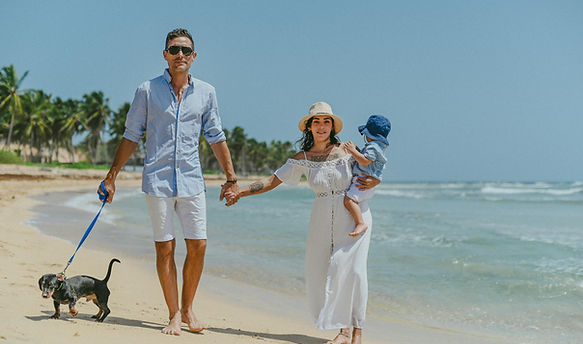 Family with their child and dog walking along the beach during a family photoshoot in Uvero Alto, Punta Cana