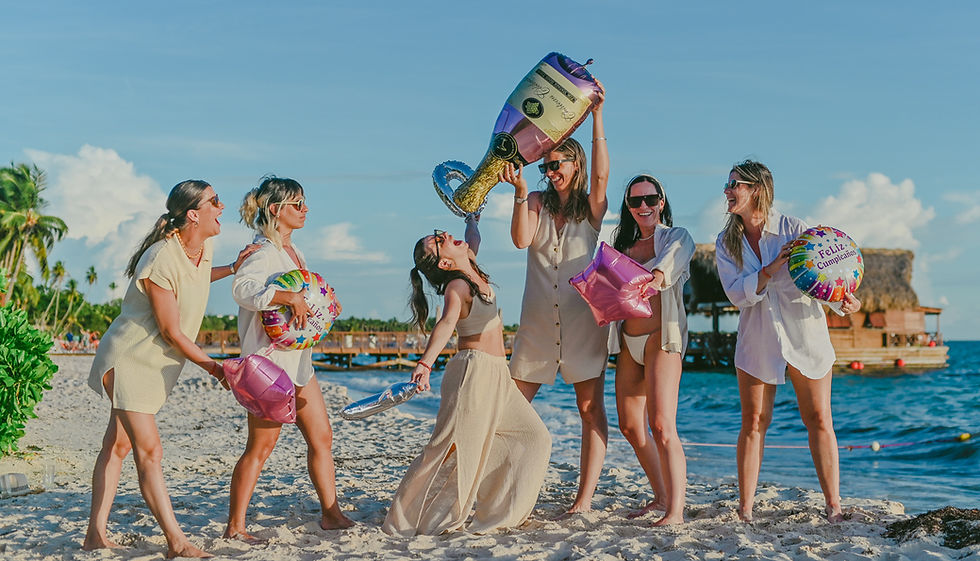 Group of friends celebrating a 40th birthday with champagne and inflatables in Bayahibe Beach near Dreams Dominicus, Dominican Republic