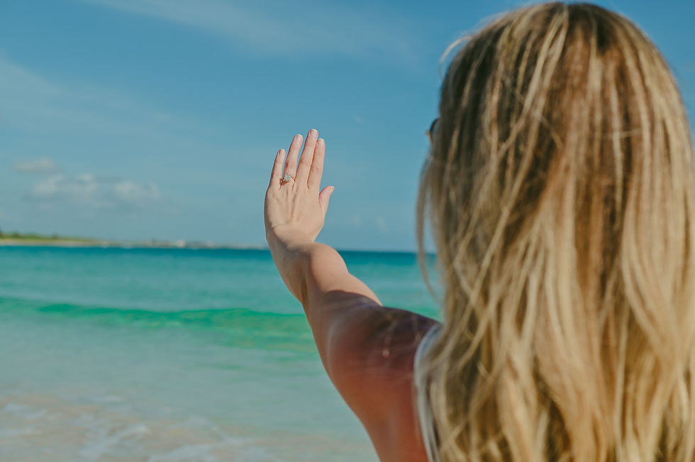 Mujer embarazada mostrando su anillo de compromiso frente al mar Caribe en Punta Cana