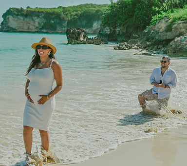 Pedro kneeling with an engagement ring while Maria faces the Caribbean Sea, moments before his surprise marriage proposal at Macao Beach, Punta Cana.