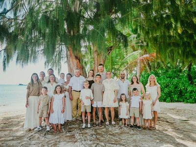 Multigenerational family of 21 people gathered under an old pine tree during a family vacation at Barcelo Punta Cana Dominican Republic