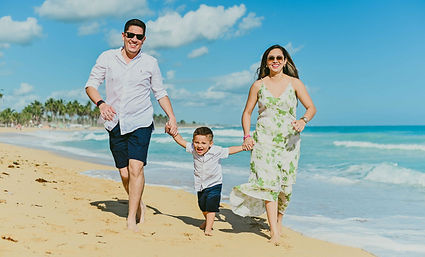Parents running and playing with their son during a family photoshoot at Macao Beach in Punta Cana.