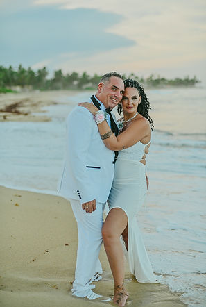 Couple during their vow renewal in Uvero Alto, Punta Cana, beside their beach ceremony gazebo.
