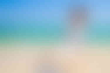 Novio levantando a la novia en brazos durante una sesión trash the dress en la playa de Punta Cana