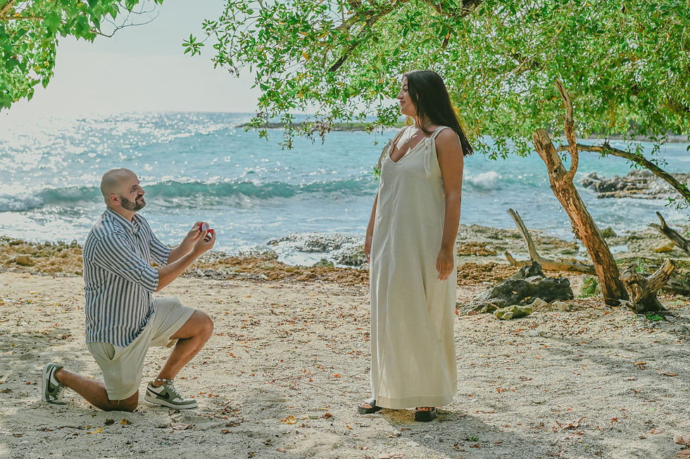Propuesta de matrimonio sorpresa en una playa de Bayahibe, con un hombre arrodillado entregando un anillo a su pareja durante una sesión de fotos en República Dominicana.
