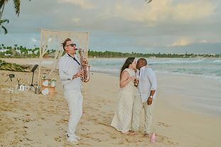 Ceremonia de boda simbólica en Playa Uvero Alto con saxofón en vivo durante una sesión de fotos en Punta Cana