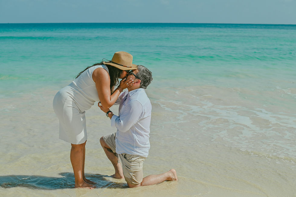 El esperado sí: beso tras la propuesta de matrimonio sorpresa durante una sesión de embarazo en Playa Macao.
