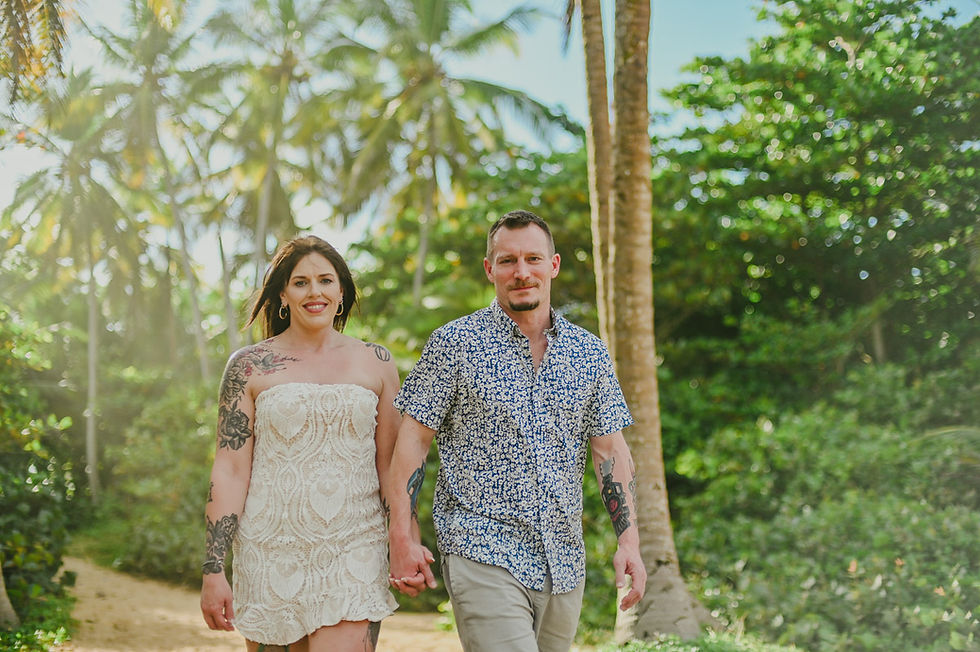 pareja tatuada caminando de cerca mirando a la camara durante sesion de fotos en playa Excellence Punta Cana Uvero Alto