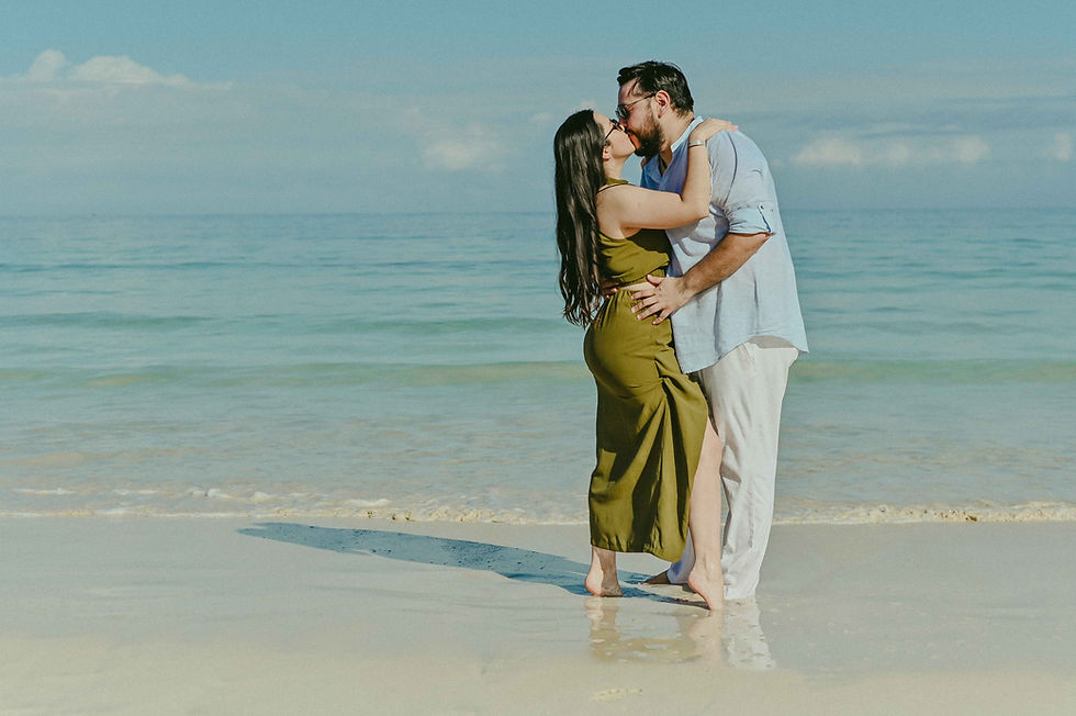 Romantic proposal photoshoot of Mexican couple at Macao Beach Punta Cana, kissing passionately with feet intertwined in the Caribbean Sea.