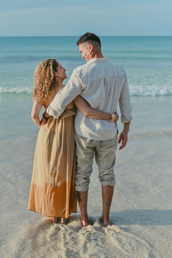Parents hugging from behind while looking at the ocean at Macao Beach during a family birthday photoshoot in Punta Cana Dominican Republic