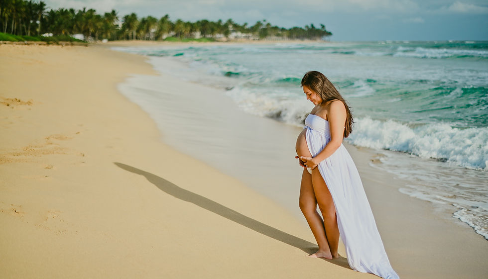 Mujer embarazada en silueta destacando su vientre al atardecer en Playa Uvero Alto durante una sesion de fotos de embarazo en Punta Cana Republica Dominicana
