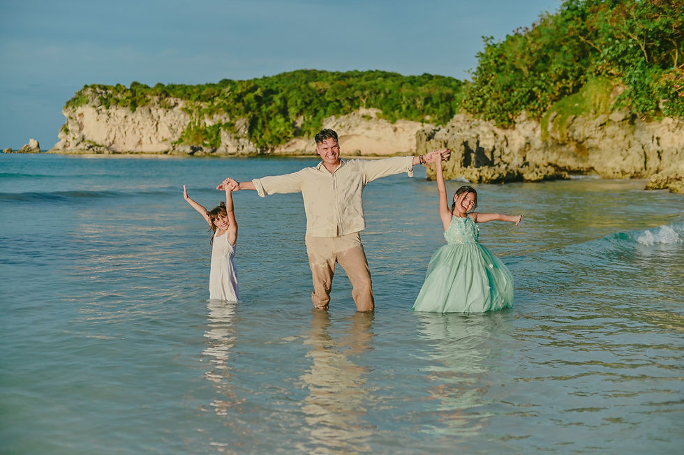 Father playing in the water with his two daughters during a family birthday photoshoot at Macao Beach in Punta Cana Dominican Republic
