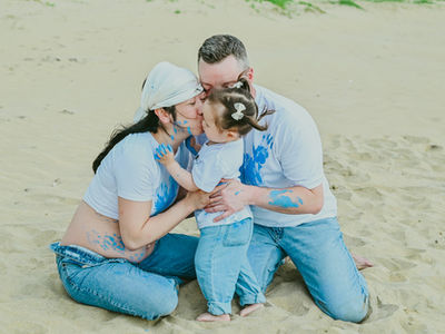 Helena and Brian celebrating a gender reveal with their daughter during a maternity photoshoot on Playa Esmeralda Miches near Dreams Playa Esmeralda Resort.