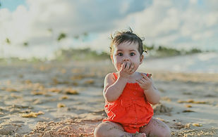 Baby sitting alone playing with sand during a first birthday photoshoot in Macao Beach, Dominican Republic