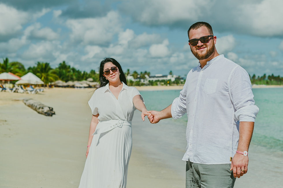 Pareja uruguaya sonriendo y tomada de la mano junto al mar durante su sesión de fotos en Playa Macao.