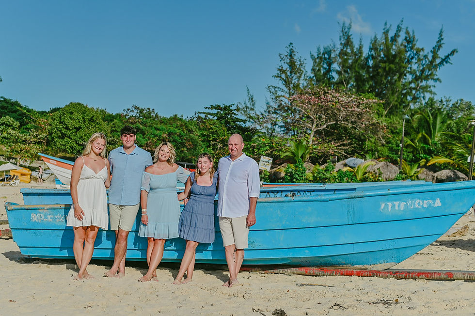 Family posing together by a traditional fishing boat during a family photoshoot at Macao Beach in Punta Cana with a local photographer.