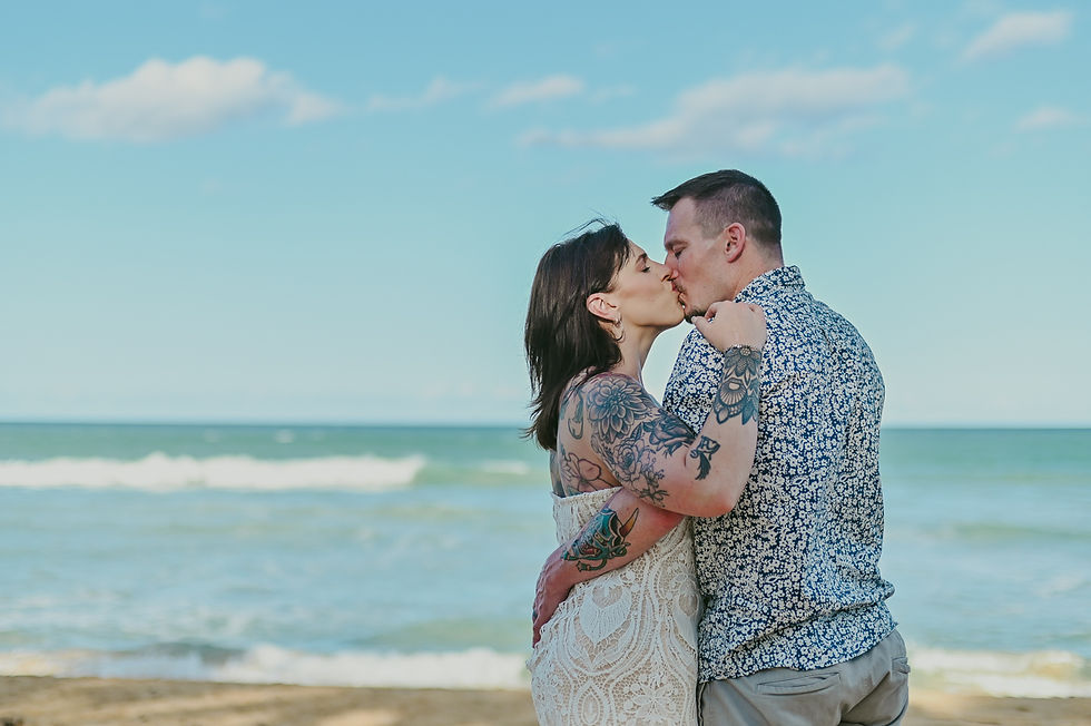 tattooed couple kissing and embracing with the Caribbean sea in the background during a post wedding photoshoot near Excellence Punta Cana Uvero Alto Dominican Republic

