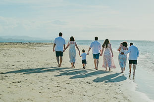 Tres generaciones de una familia caminando juntas durante una sesión de fotos en Playa Esmeralda, Miches