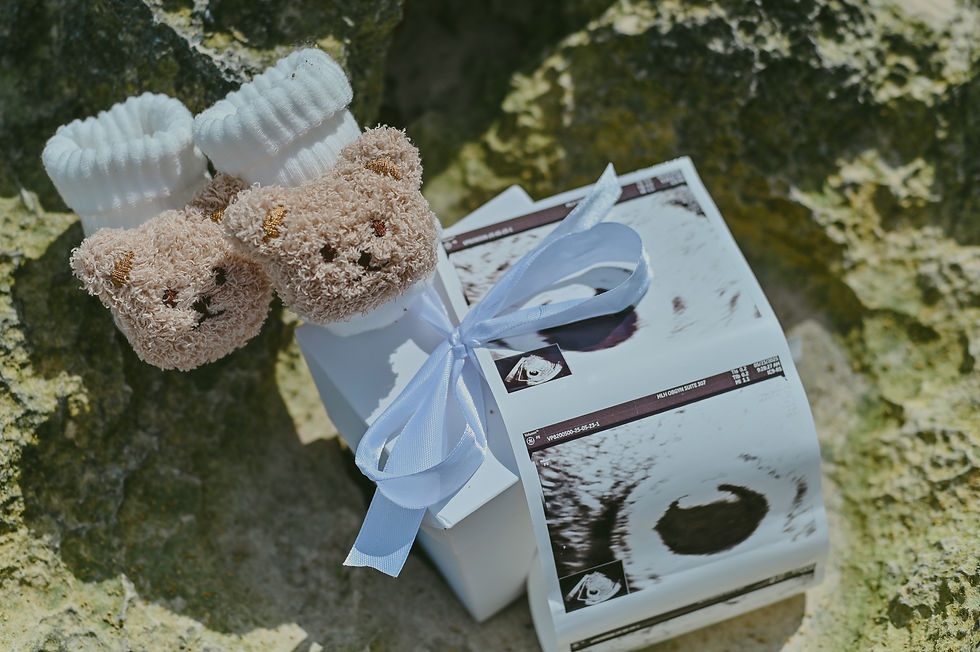 Ecografía y pequeños soquetes de bebé colocados en la arena durante una sesión de fotos de embarazo en Playa Macao, Punta Cana.