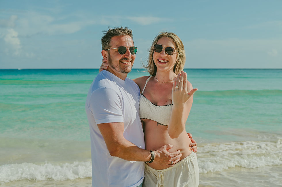 Pareja sonriendo y mostrando el anillo de compromiso durante una sesion de embarazo en Punta Cana