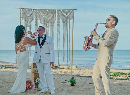 Live saxophonist performing during a vow renewal on Uvero Alto Beach in Punta Cana as the couple celebrates in front of a romantic ceremony gazebo.