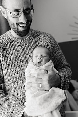 dad holding yawning newborn baby